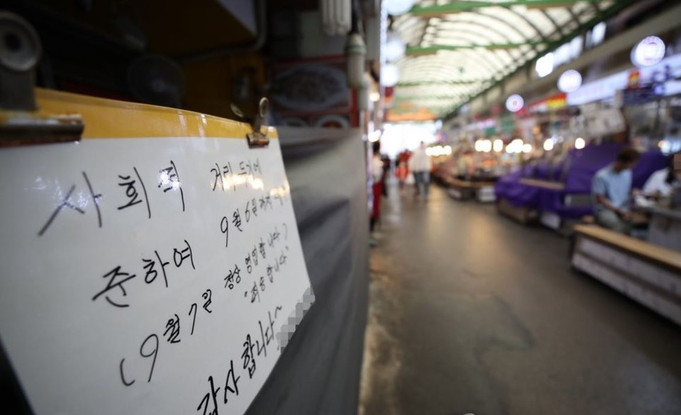 코로나19 재확산으로 썰렁한 서울 광장시장 내 한 가게에 사회적 거리두기에 따른 휴무 안내문이 붙어있다.