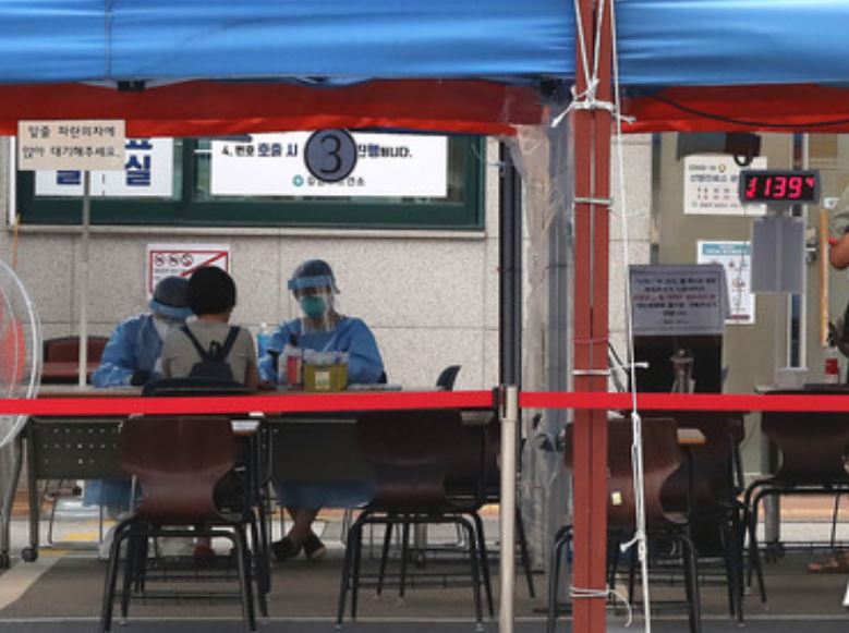16일 오후, 서울 강남구보건소에 한 시민이 코로나19 진단 검사를 받기 위해 의료진의 설명을 듣고 있다.