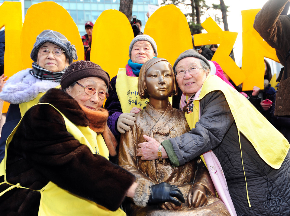 일본군 위안부 문제 해결을 위한 정기 수요집회 1000회가 2011년 12월 14일 열린 가운데 고 김원옥(오른쪽), 김복동(왼쪽) 할머니가 소녀상을 안고 있다.(사진=정의기억연대)
